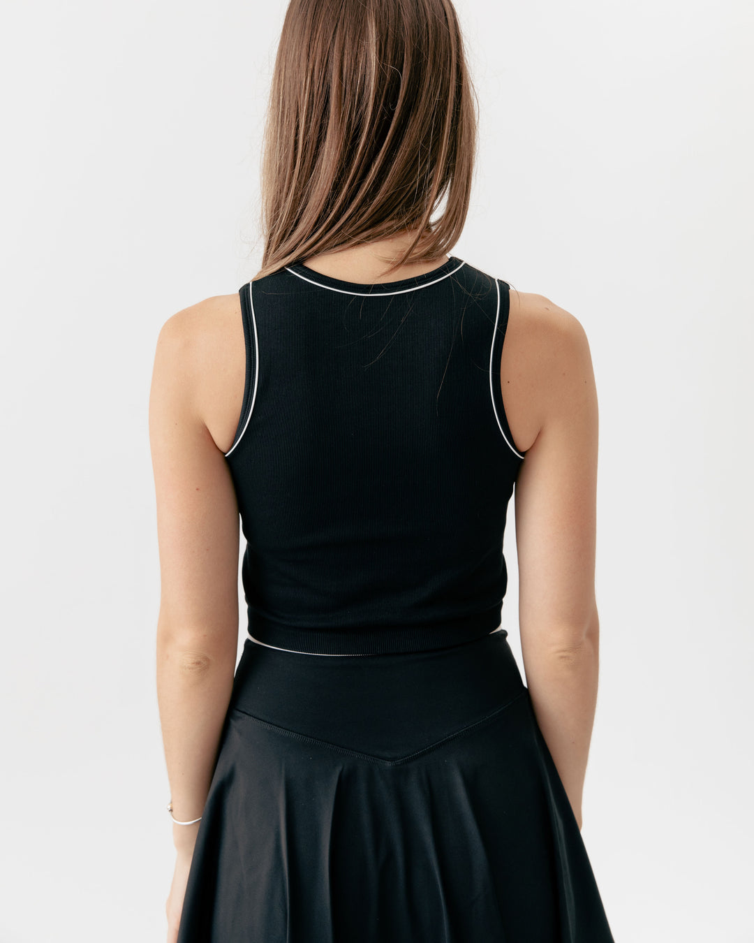 high-neck crop tank top paired with a matching crossover V-waist tennis skirt