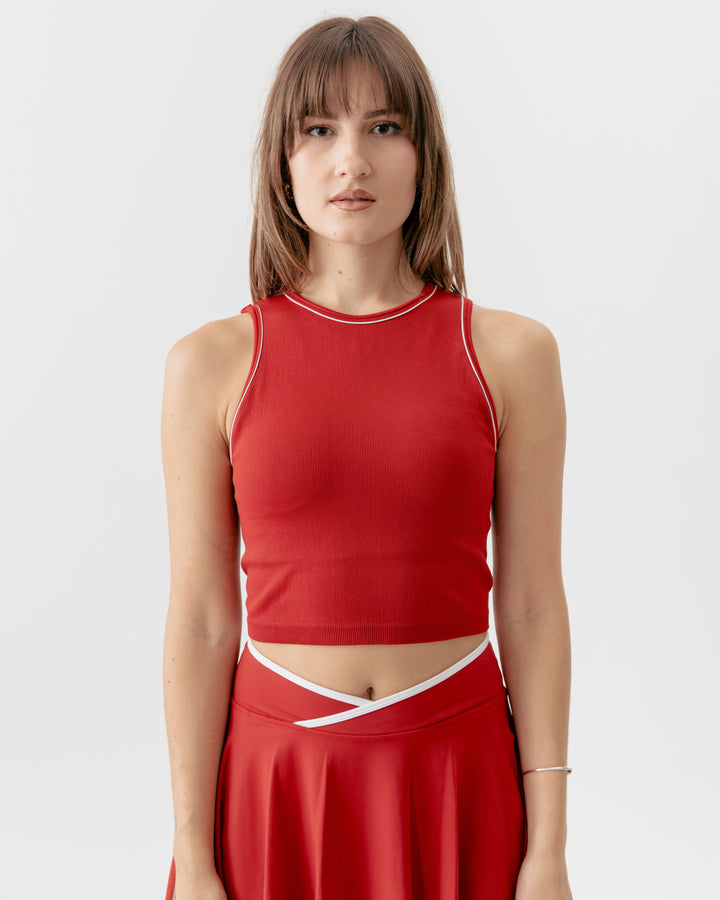 Woman wearing a red sleeveless top and skirt on a white background