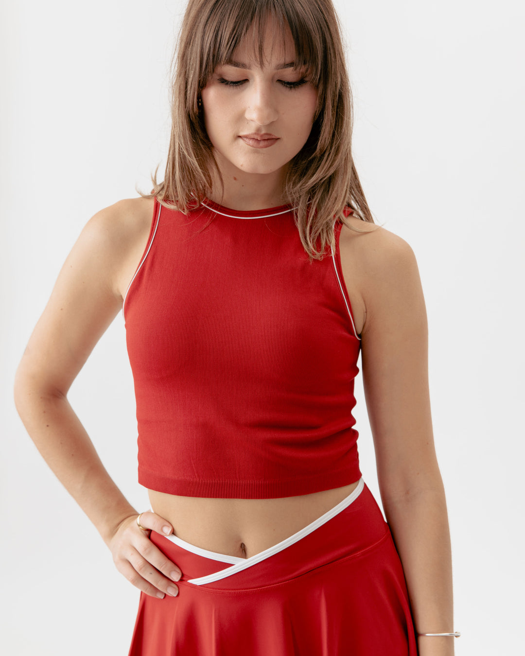 Woman wearing a red sleeveless top and skirt on a white background