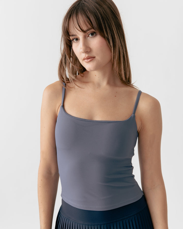 Woman wearing a charcoal camisole square neck tank top against a plain background