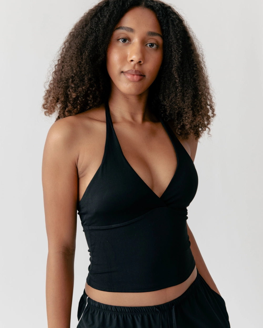 Woman wearing a black halter top against a plain background