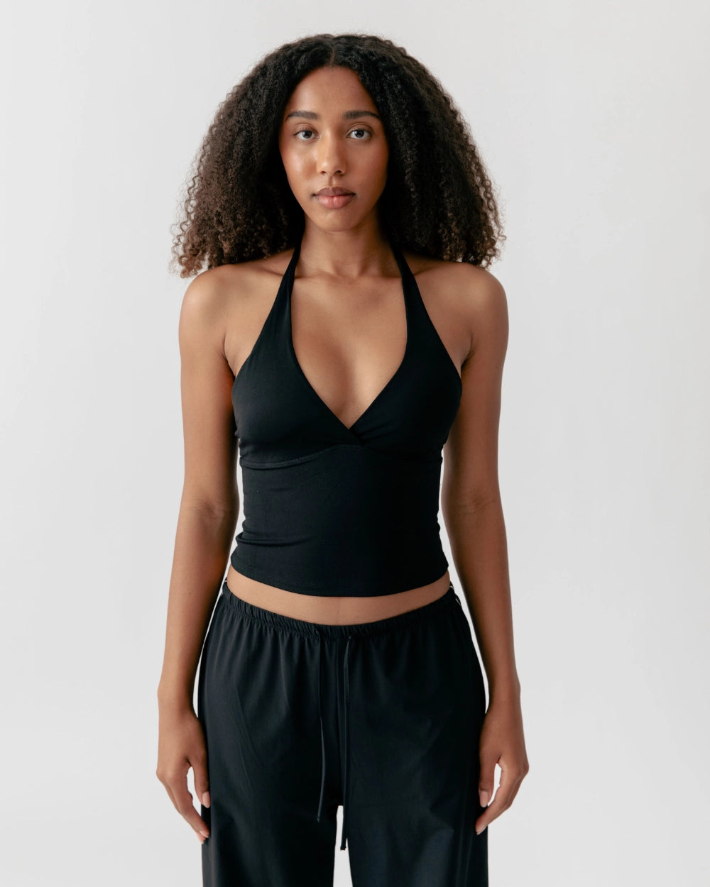 Woman wearing a black sports bra and leggings on a white background