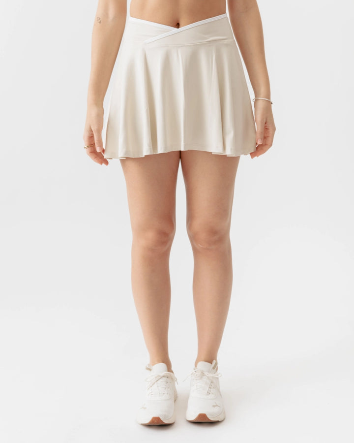 Person wearing a white skirt on a plain background