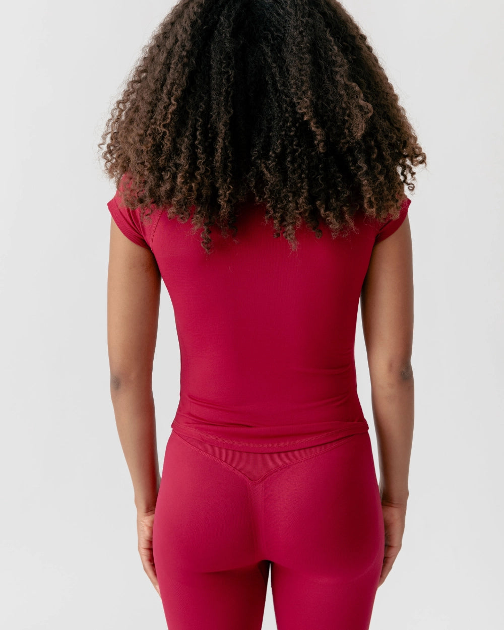 Person wearing a red athletic outfit on a plain background