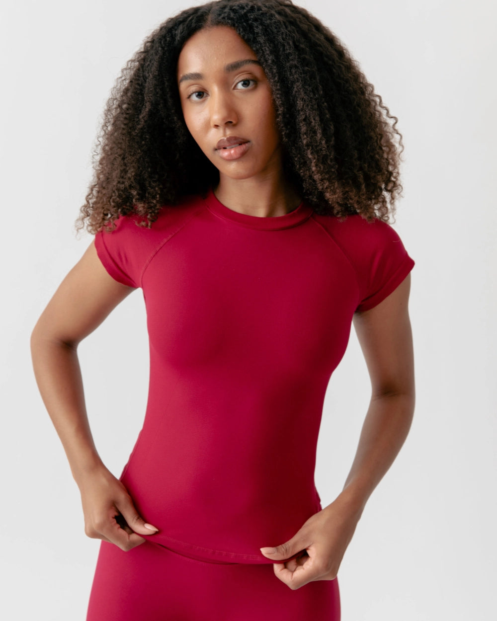 Woman wearing a red athletic outfit on a white background