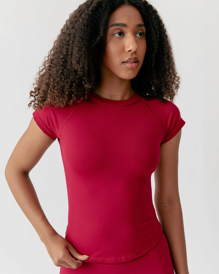 Woman wearing a red t-shirt against a plain background