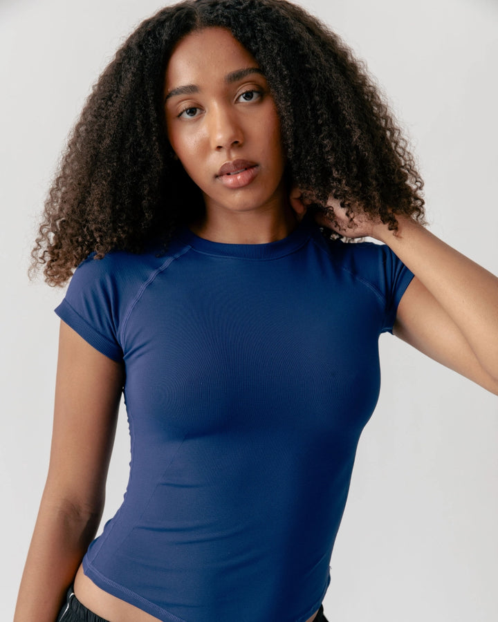 Woman wearing a blue t-shirt against a plain background