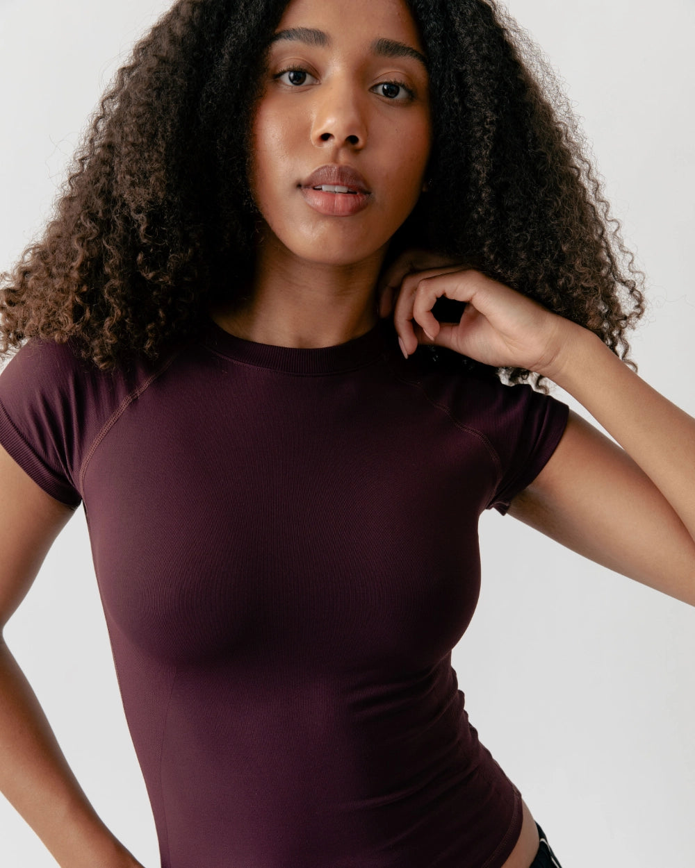 Woman wearing a maroon t-shirt against a plain background