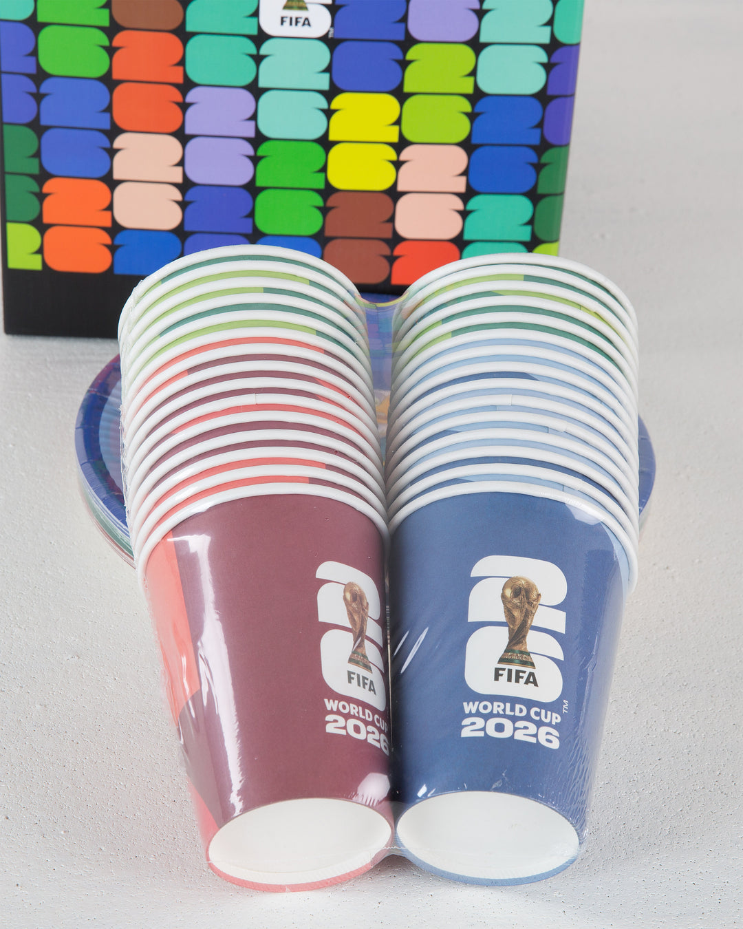 A set of red and blue FIFA World Cup 2026 Paper Cups behind a plate and box