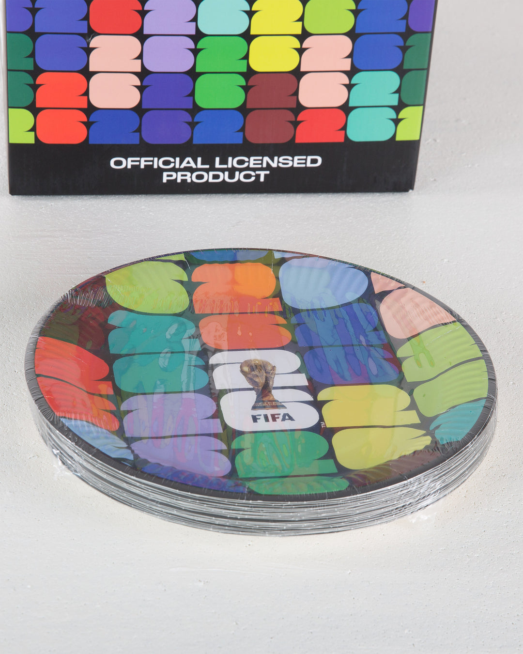 Stack of colorful coasters with FIFA logo, in front of a branded box.