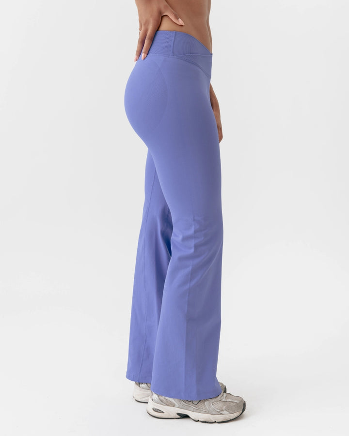 Person wearing purple flared pants on a white background