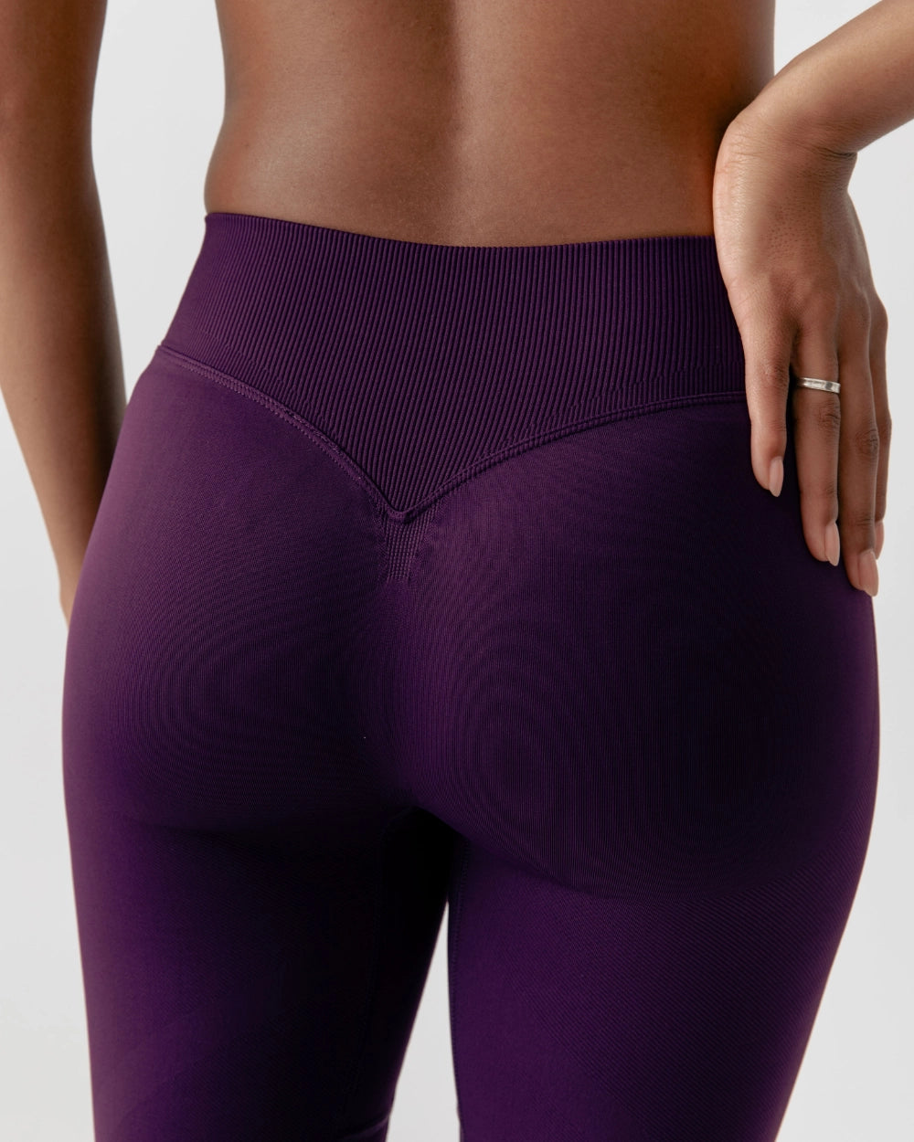 Purple leggings worn by a person on a light gray background