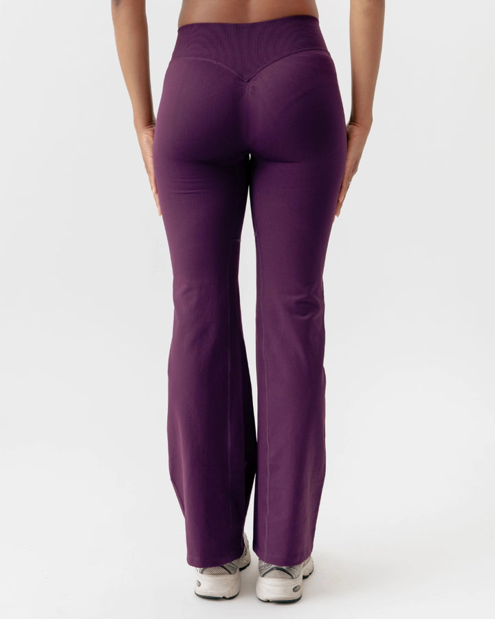 Purple leggings worn by a person on a white background