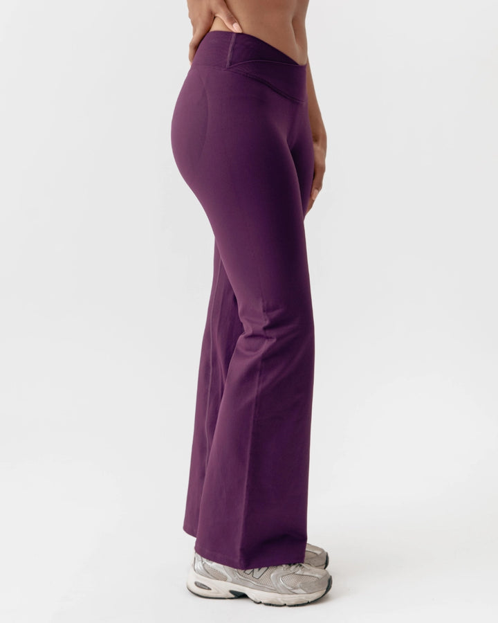Purple pants worn by a person on a white background