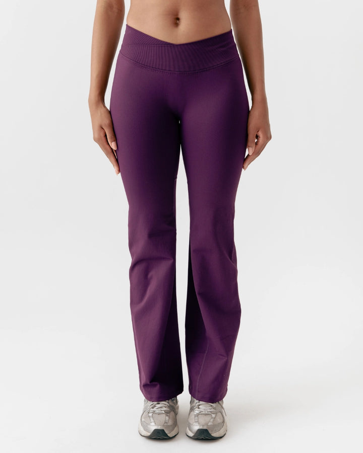Purple pants worn by a person on a white background