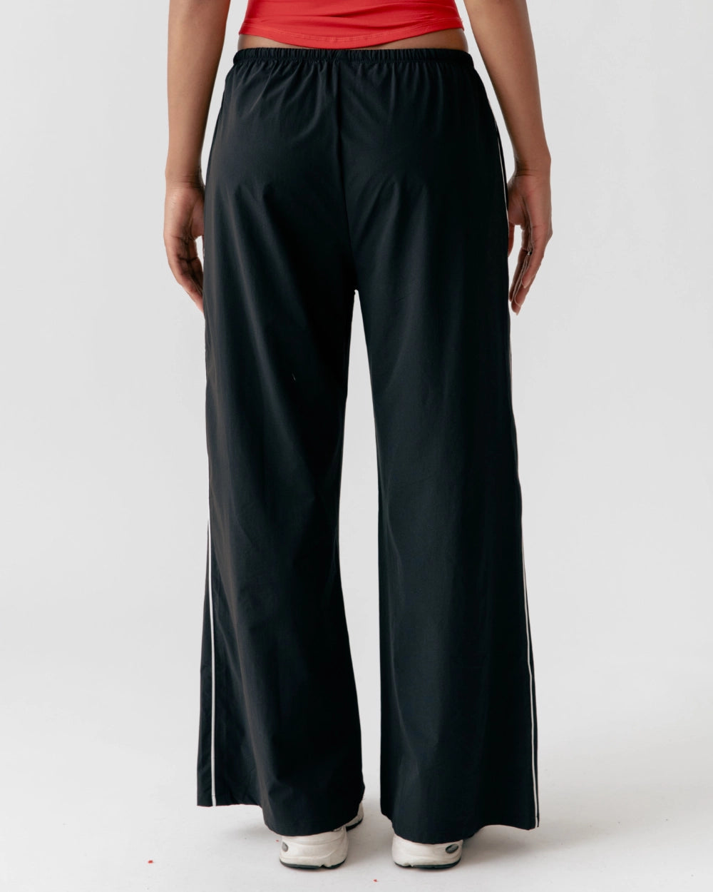Person wearing black wide-leg pants on a white background