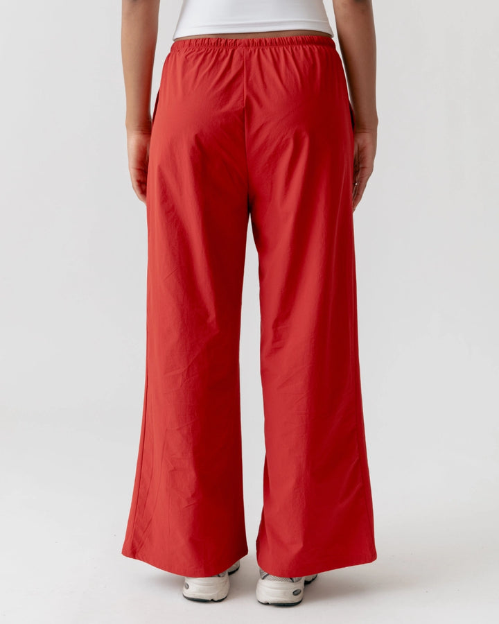 Red pants worn by a person on a white background