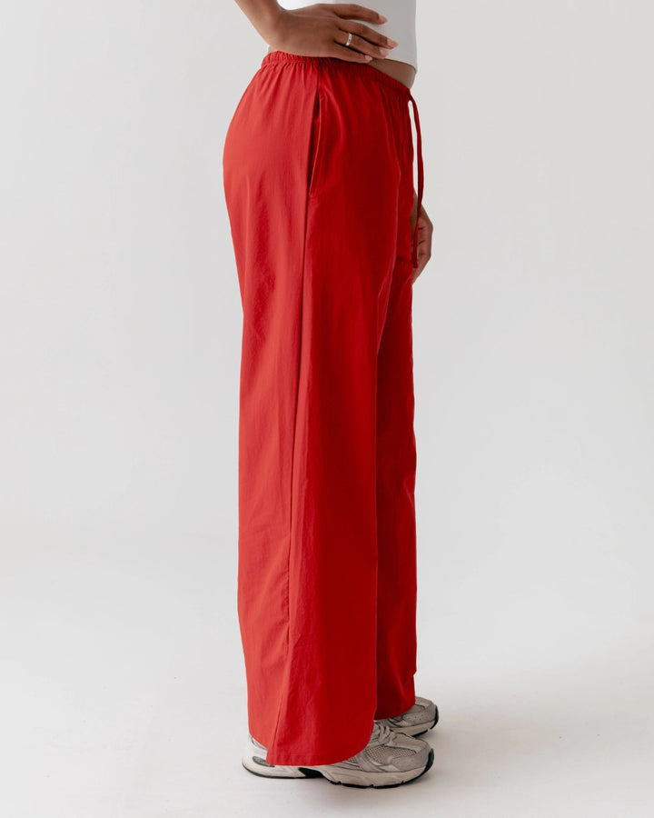 Red wide-leg pants worn by a person on a white background