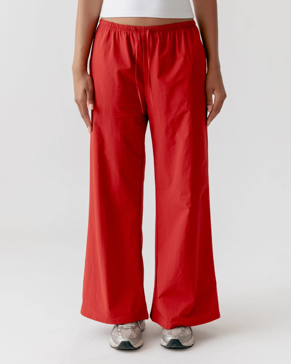 Person wearing red wide-leg pants on a white background