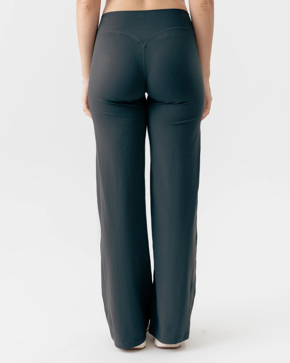 Dark green pants worn by a person on a white background