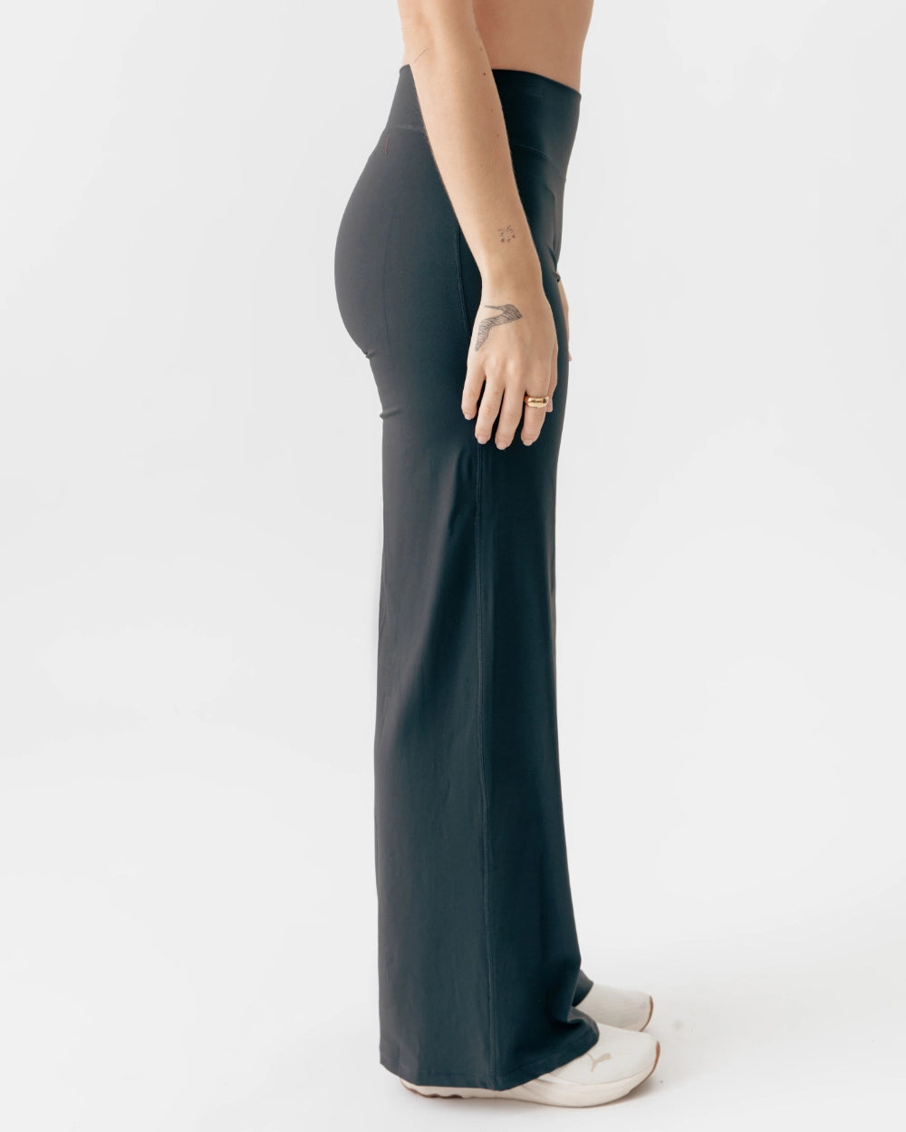 Person wearing dark green wide-leg pants on a white background