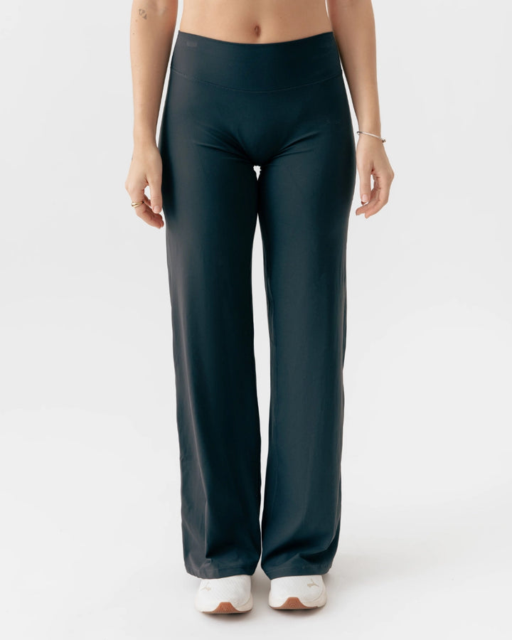 Person wearing dark green wide-leg pants on a white background