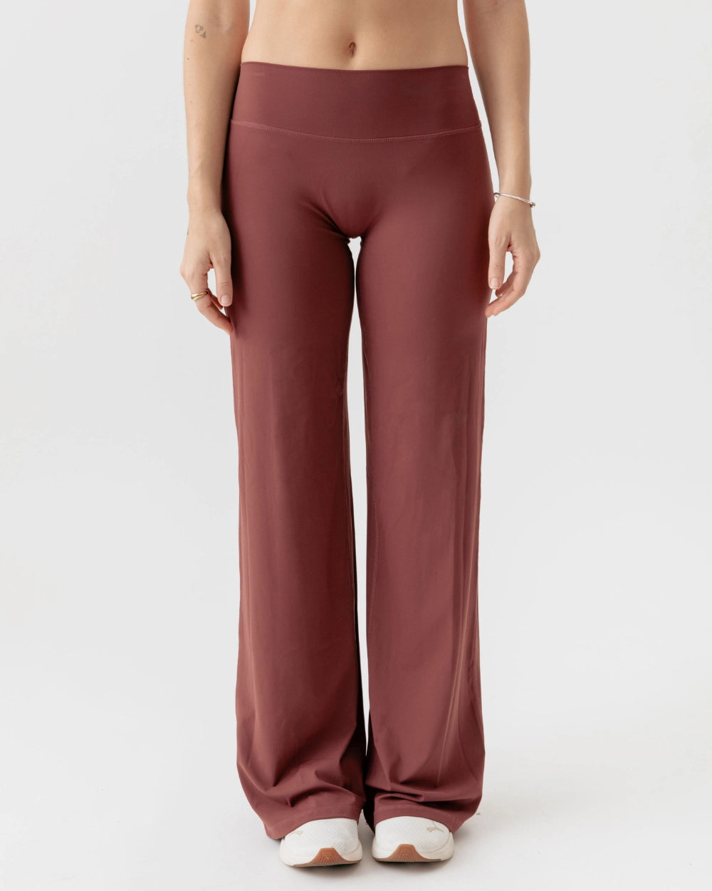 Maroon high-waisted pants worn by a person on a white background