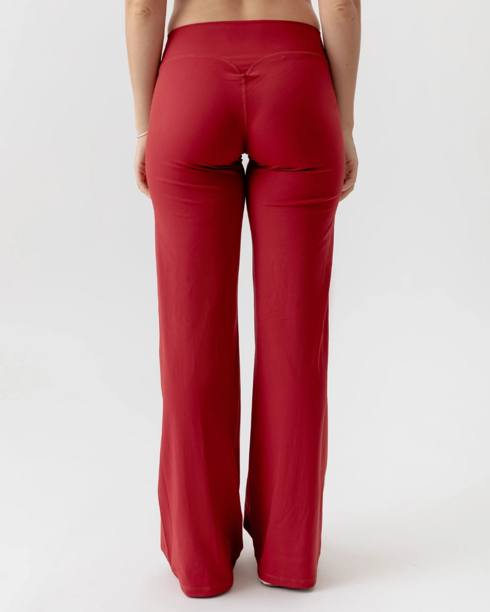 Red pants worn by a person on a white background