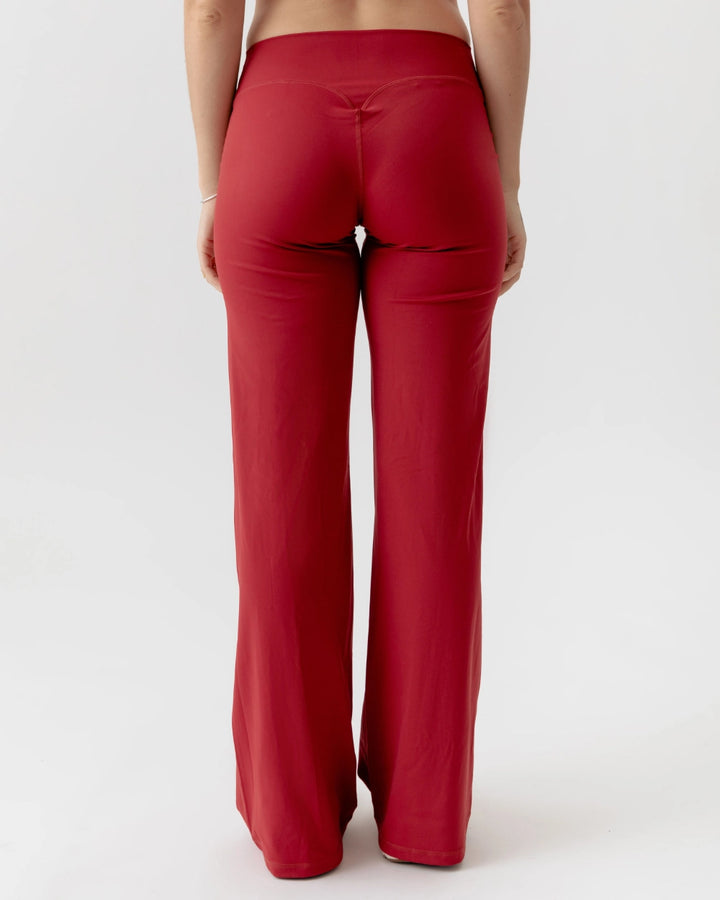 Red pants worn by a person on a white background