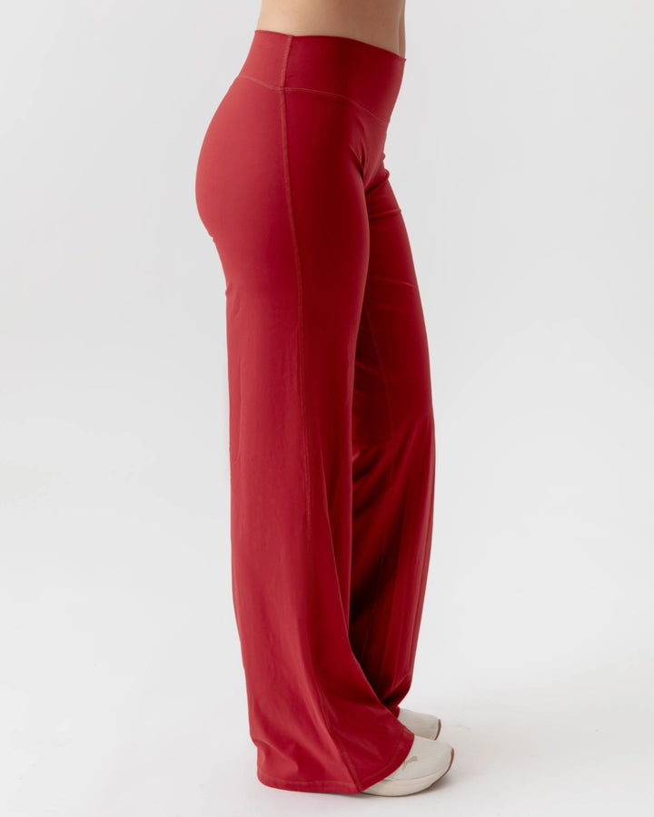 Red wide-leg pants worn by a person on a white background
