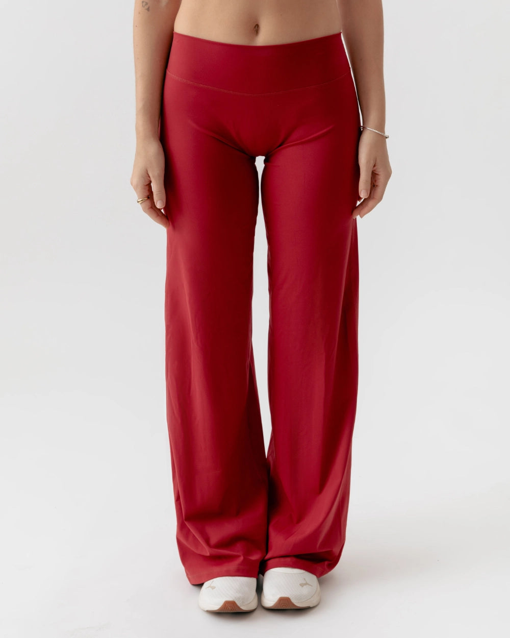Red high-waisted pants worn by a person on a white background